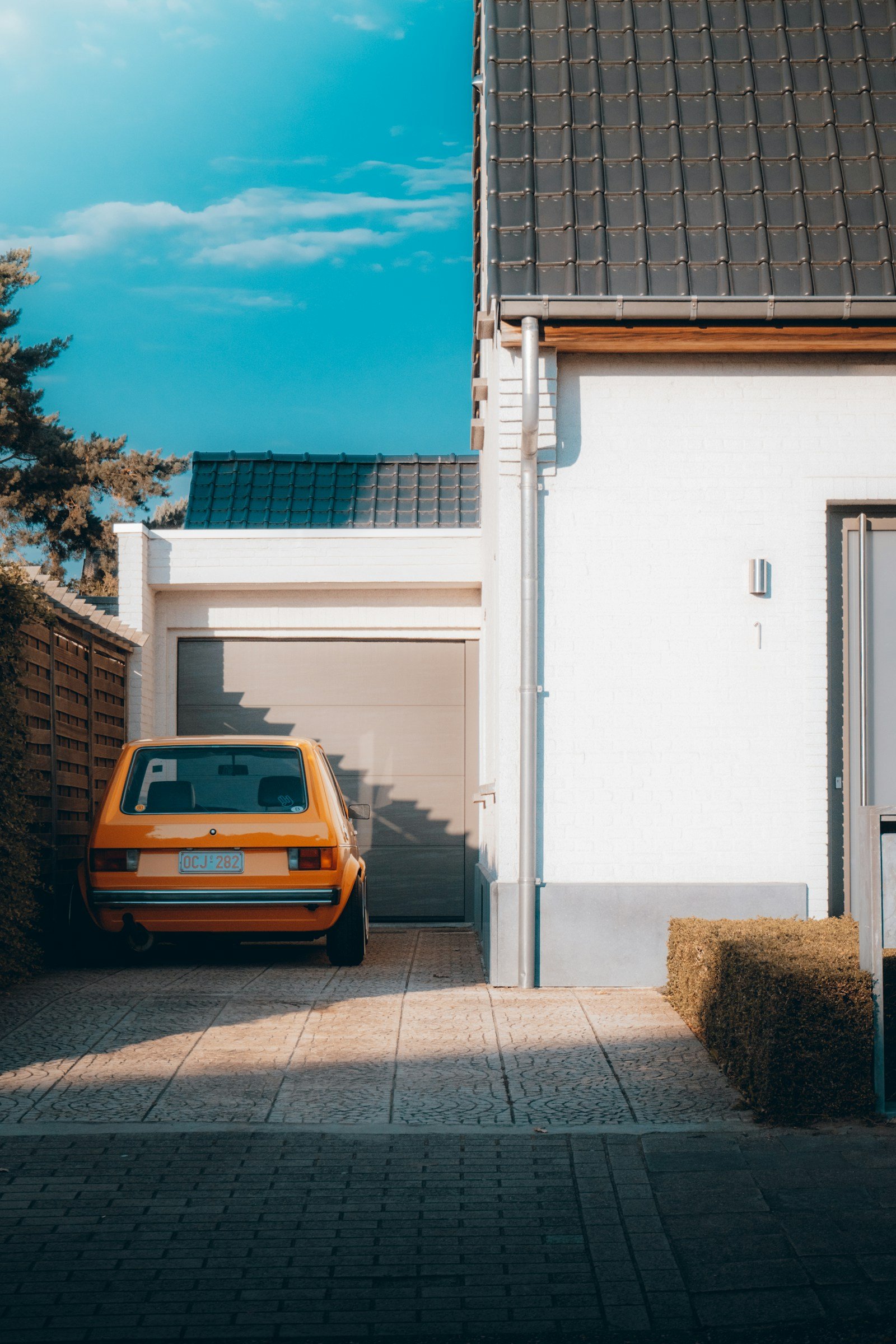 Modern grey sectional garage door on a white brick home